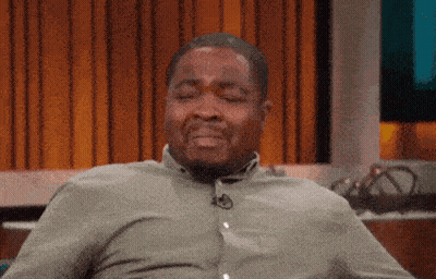 A Man Wearing A Green Shirt Is Sitting With His Eyes Closed GIF