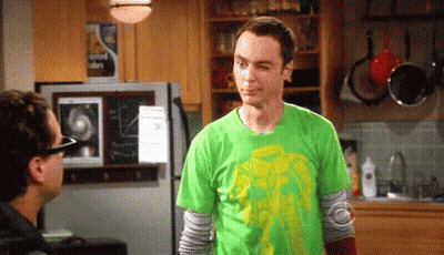 A Man Wearing A Green Shirt Is Standing In A Kitchen Next To A Refrigerator . GIF