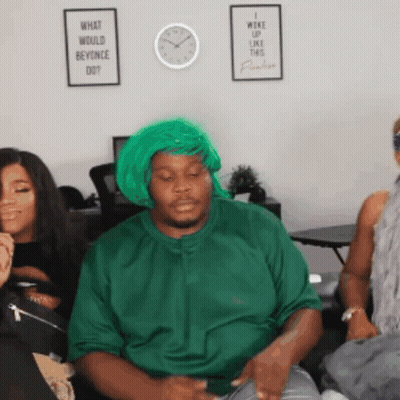 A Man Wearing A Green Wig And A Green Shirt Is Sitting On A Couch With Two Women . GIF
