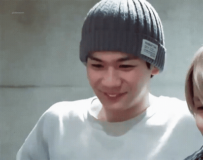 A Man Wearing A Grey Beanie With A Manhattan City Logo On It GIF