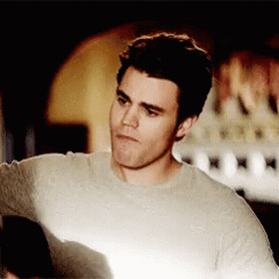 A Man Wearing A Grey Sweater Looks At Something GIF