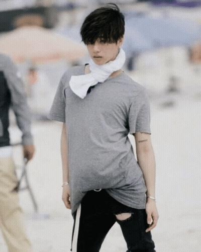 A Man Wearing A Grey T-Shirt And Black Ripped Jeans GIF