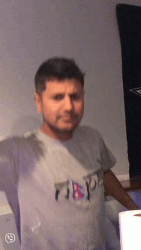 A Man Wearing A Grey T-Shirt That Says ' Nepal ' On It GIF