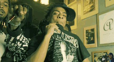 A Man Wearing A Guess T-Shirt Smoking A Cigarette GIF