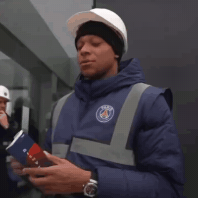 a man wearing a hard hat and a blue jacket with the word paris on it