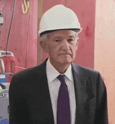 A Man Wearing A Hard Hat And A Suit GIF