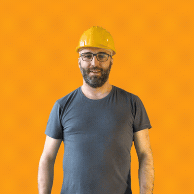 A Man Wearing A Hard Hat And Glasses Holds His Fist Up In The Air GIF