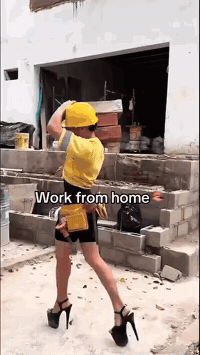 A Man Wearing A Hard Hat And High Heels Is Carrying Bricks . GIF