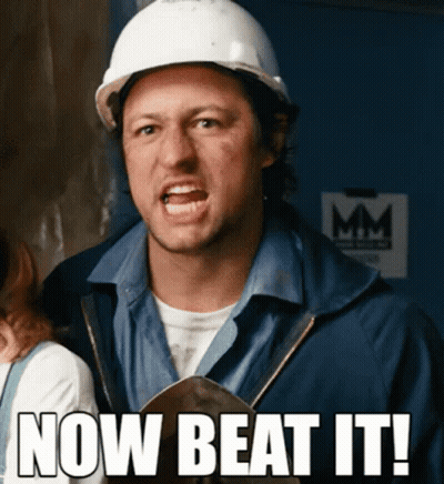 A Man Wearing A Hard Hat With The Words Now Beat It Written Below Him GIF