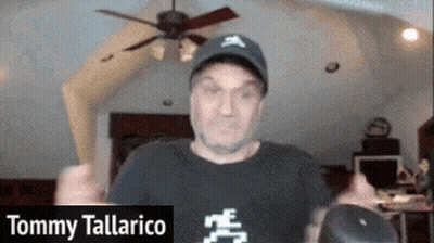 A Man Wearing A Hat And A Black Shirt Is Named Tommy Tallarico GIF