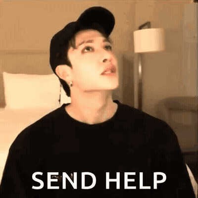 A Man Wearing A Hat And A Black Shirt Is Standing In A Room With The Words `` Send Help '' . GIF