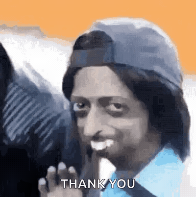 A Man Wearing A Hat And A Blue Shirt Is Giving A Thank You Gesture . GIF