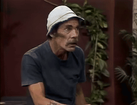 A Man Wearing A Hat And A Blue Shirt Is Sitting Down GIF