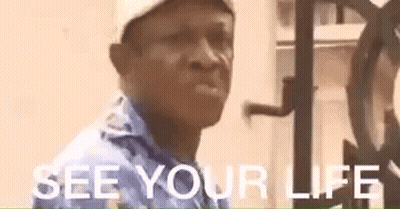 A Man Wearing A Hat And A Blue Shirt Is Standing In Front Of A Clock And Says `` See Your Life '' . GIF