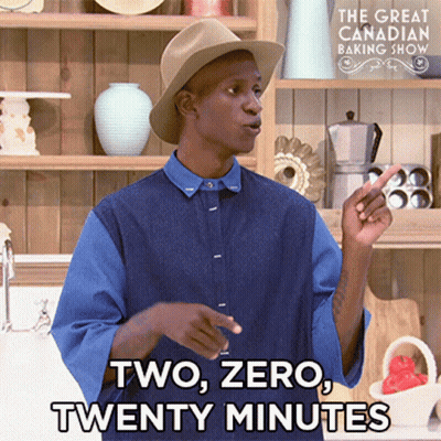 A Man Wearing A Hat And A Blue Shirt Is Standing In Front Of A Sign That Says The Great Canadian Baking Show GIF