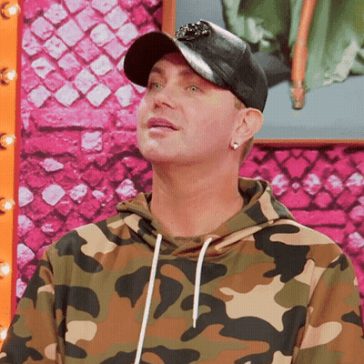 A Man Wearing A Hat And A Camouflage Sweatshirt GIF
