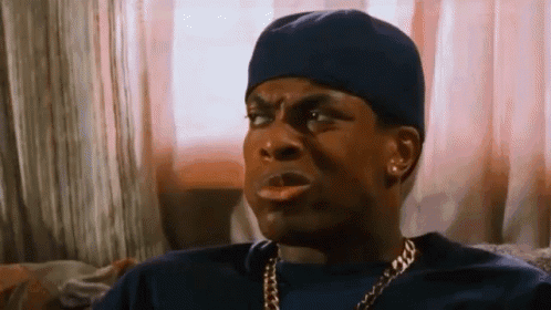 A Man Wearing A Hat And A Chain Is Sitting On A Couch . GIF