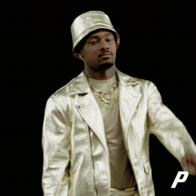 A Man Wearing A Hat And A Gold Jacket With The Letter P In The Corner GIF