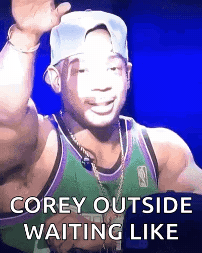 A Man Wearing A Hat And A Green Jersey Is Waiting Like Corey Outside GIF