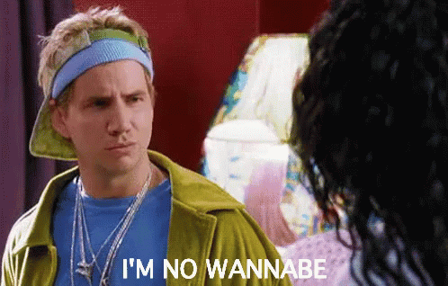 A Man Wearing A Hat And A Headband Says I 'M No Wannabe . GIF
