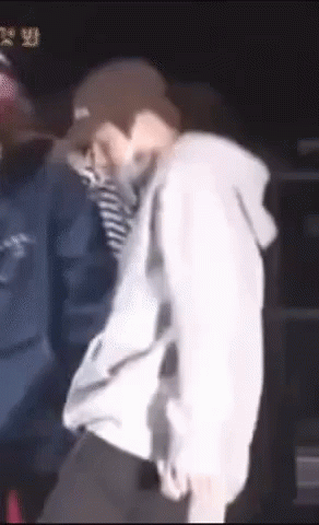 A Man Wearing A Hat And A Hoodie Is Dancing On A Stage GIF