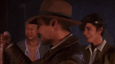 A Man Wearing A Hat And A Jacket Is Smiling In Front Of Two Other Men . GIF