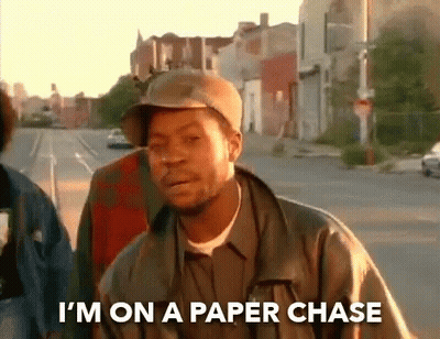 A Man Wearing A Hat And A Jacket Is Walking Down A Street And Says I 'M On A Paper Chase GIF