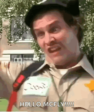 A Man Wearing A Hat And A Name Tag That Says Hello Mcfly . GIF