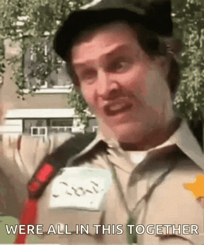 A Man Wearing A Hat And A Name Tag With The Words Were All In This Together Written On It GIF