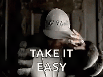 A Man Wearing A Hat And A Necklace Is Holding A Stuffed Animal And Saying `` Take It Easy '' . GIF