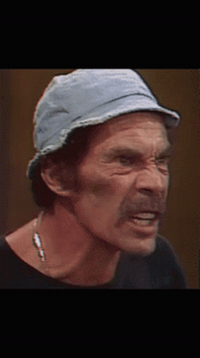 A Man Wearing A Hat And A Necklace Looks Down GIF