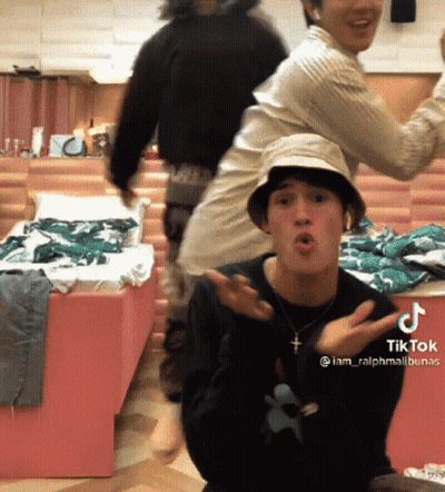 A Man Wearing A Hat And A Necklace With A Cross On It Has A Tiktok Sticker On His Chest GIF