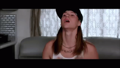 A Man Wearing A Hat And A Necklace With The Word Ragro On His Neck GIF