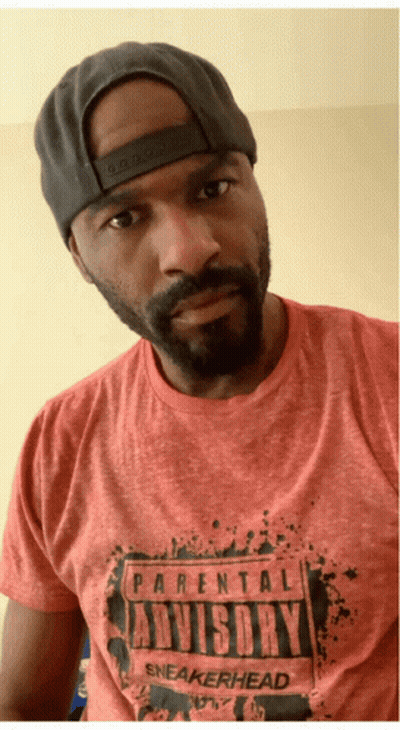 A Man Wearing A Hat And A Parental Advisory Sneakerhead Shirt GIF