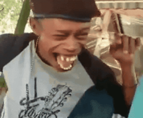 A Man Wearing A Hat And A Shirt That Says Clown Is Laughing GIF