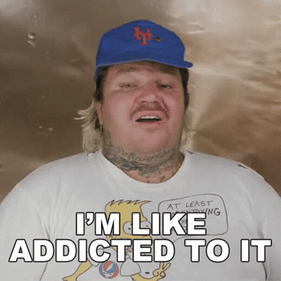 A Man Wearing A Hat And A Shirt That Says I 'M Like Addicted To It On It GIF