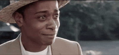 A Man Wearing A Hat And A Suit Is Crying With His Eyes Closed . GIF