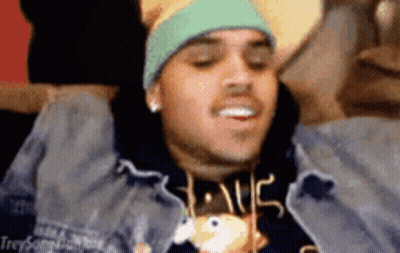 A Man Wearing A Hat And A Sweatshirt With The Word Love On It Is Laying On A Couch . GIF