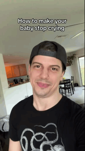 A Man Wearing A Hat And A T-Shirt That Says How To Make Your Baby Stop Crying Takes A Selfie GIF
