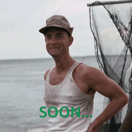 A Man Wearing A Hat And A Tank Top Is Standing In Front Of A Body Of Water With The Word Soon Written On The Bottom GIF