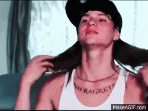 A Man Wearing A Hat And A Tank Top That Says No Regrets On His Chest GIF
