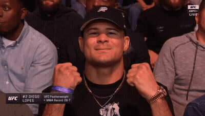 A Man Wearing A Hat And A Watch Is Sitting In A Crowd Watching Ufc GIF