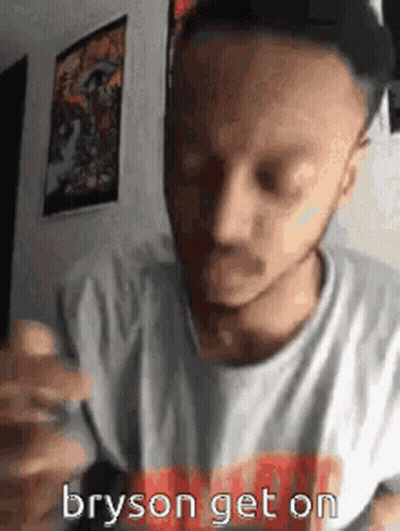 A Man Wearing A Hat And A White Shirt Is Eating A Hamburger And Says Bryson Get On . GIF