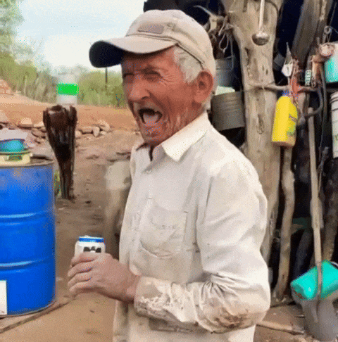 A Man Wearing A Hat And A White Shirt Is Holding A Can Of Beer GIF