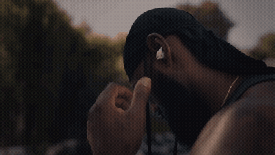 A Man Wearing A Hat And Ear Buds With The Letter O On It GIF