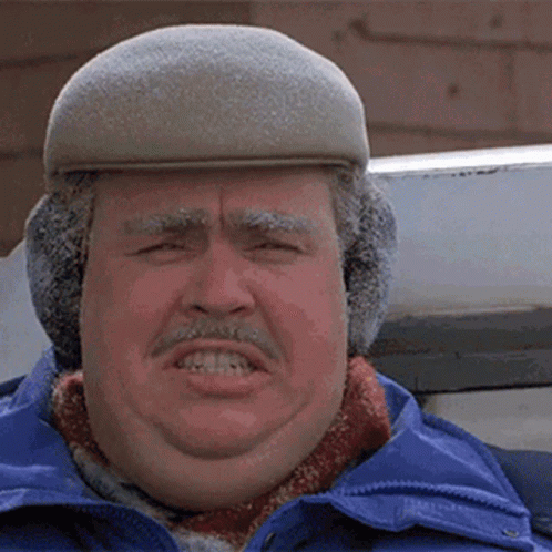 A Man Wearing A Hat And Ear Muffs Makes A Face GIF