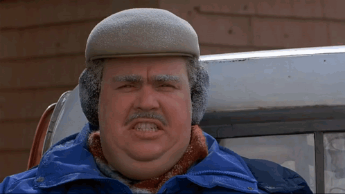 A Man Wearing A Hat And Ear Muffs Makes A Funny Face GIF