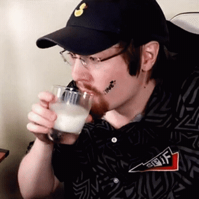 A Man Wearing A Hat And Glasses Is Drinking From A Glass . GIF
