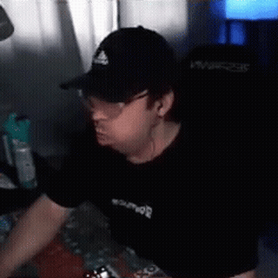 A Man Wearing A Hat And Glasses Is Sitting In Front Of A Computer . GIF