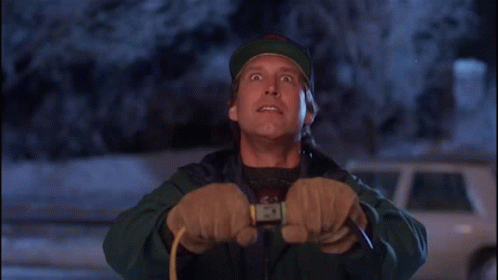 A Man Wearing A Hat And Gloves Is Holding A Rope And Looking Up GIF